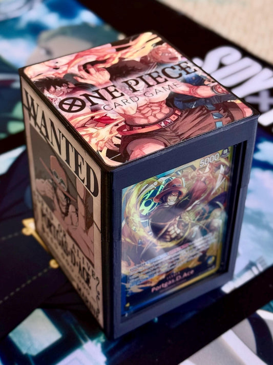 May include: A black card game deck box with a 'One Piece Card Game' design. The top of the box features a wanted poster with a character from the anime series One Piece. The side of the box features a card from the game with a character from the anime series One Piece. The card reads '5000' and 'Portgas D. Ace'.
