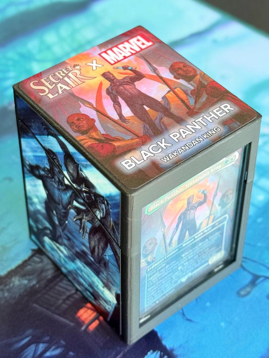 May include: A black and gray Secret Lair x Marvel Black Panther Wakandan King deck box with a blue and green image of Black Panther on the front and a blue and green card with text on the back.